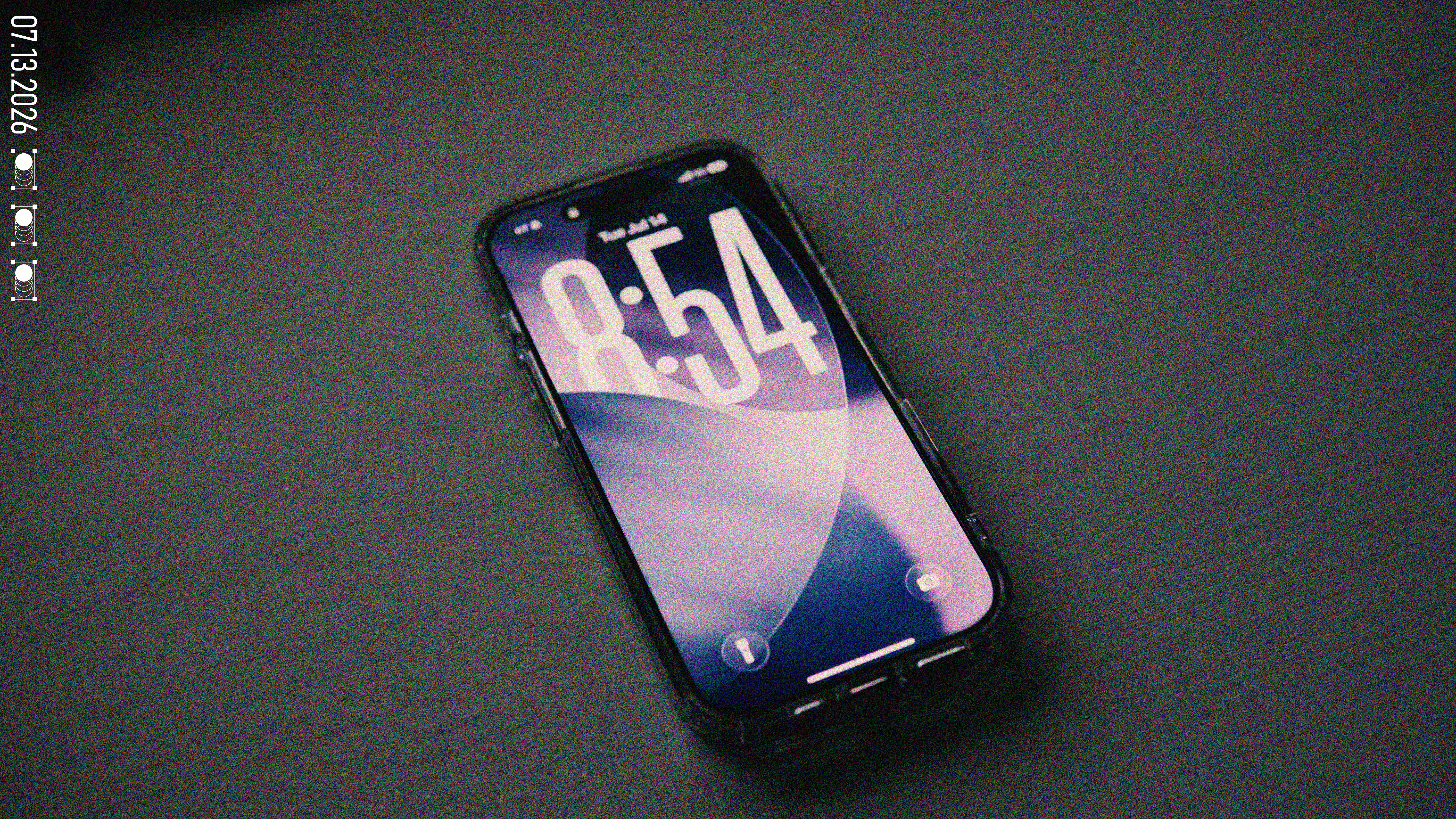 The iPhone 17 lying flat on a dark desk surface